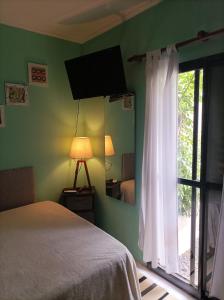 een slaapkamer met een bed, een spiegel en een raam bij Rinacasaquinchoypile in Paraná