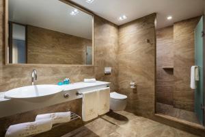 ein Badezimmer mit einem Waschbecken, einem WC und einem Spiegel in der Unterkunft -- ESTE PARK HOTEL -- part of Urban Chic Luxury Design Hotels - Parking & Compliments - next to Shopping & Dining Mall Plovdiv in Plowdiw