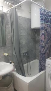 a bathroom with a shower curtain and a bath tub at Apartman Maja in Bijeljina