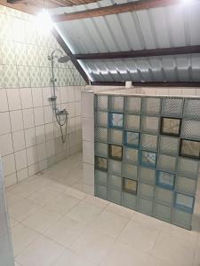 uma casa de banho com chuveiro e azulejos na parede em Hotel restaurant Foulpointe Loisir em Foulpointe