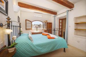 una camera da letto con un letto blu in una stanza di Oleandra Holiday Home a Għasri