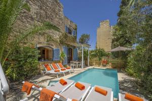 une villa avec une piscine et une maison dans l'établissement Oleandra Holiday Home, à Għasri
