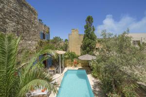 ein Pool in einem Hof neben einem Gebäude in der Unterkunft Oleandra Holiday Home in Għasri