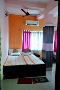 a bedroom with a large bed with pink curtains at hotel sagnik in Murshidābād