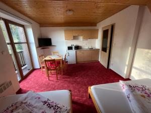 a room with a kitchen and a table and chairs at Chata Boubín in Kubova Huť