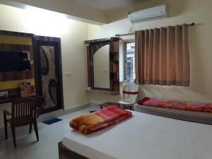a bedroom with a bed and a desk and a mirror at hotel sagnik in Murshidābād
