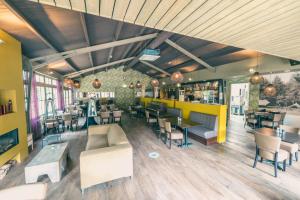 un restaurante con mesas y sillas y un bar en EuroParcs De Utrechtse Heuvelrug en Maarn