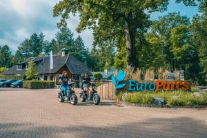 two people on motorcycles parked in a parking lot at EuroParcs De Utrechtse Heuvelrug in Maarn