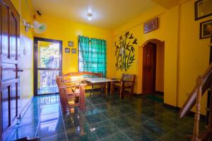a dining room with yellow walls and a table and chairs at Joval Homestay in Coron