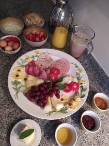 a plate of fruit on a table with eggs and juice at Domizil der Sinne in Bad Liebenwerda