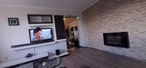 - un salon avec une télévision et un mur en briques dans l'établissement Ultracentral apartments, à Bacău