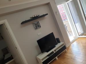 uma sala de estar com uma televisão de ecrã plano na parede em DurmitorBW em Sajmište