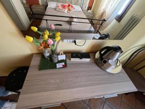 a table with flowers on it next to a bed at La Bicicletta Rifiorita in Ferrara