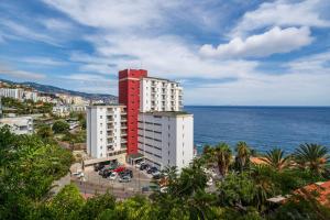 フンシャルにあるFunchal Sea View I by An Island Apartの海辺の赤白の建物