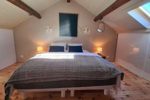 um quarto com uma cama grande e 2 almofadas azuis em La Fario - Grande maison familiale em Font Romeu Odeillo Via