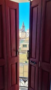 uma porta de madeira aberta com vista para um edifício em La Fario - Grande maison familiale em Font Romeu Odeillo Via