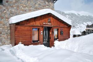 a wooden cabin with snow on top of it at Hotel Roc de St Miquel & Apartment in Soldeu
