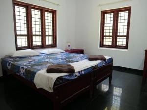 a bed in a room with two pillows on it at Secret Paradise in Varkala