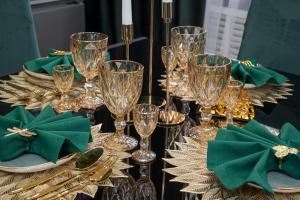 a table topped with glasses and plates with green napkins at Сдам 2-х комнатную квартиру посуточно in Uralsk