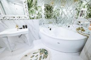 a white bathroom with a tub and a sink at Сдам 2-х комнатную квартиру посуточно in Uralsk +8 photos