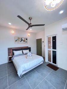 une chambre avec un grand lit avec un ventilateur de plafond dans l'établissement 608 Ocean View 3 bedrooms, à Kuah