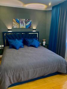 a bedroom with a large bed with blue curtains at Сдам 2-х комнатную квартиру посуточно in Uralsk