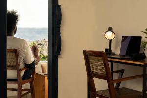 a person sitting at a desk with a computer at Zostel Alleppey in Alleppey