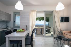 een keuken en een woonkamer met een tafel en stoelen bij Evgoro Luxury Suites in Agia Galini