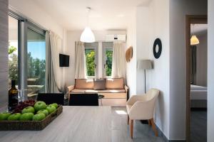 een woonkamer met een tafel met een kom appels bij Evgoro Luxury Suites in Agia Galini