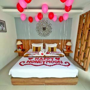 un dormitorio con una cama con globos y una luna de armonía feliz en The Sakaye Villas & Spa, en Legian