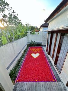 una alfombra roja con un corazón en el lateral de una casa en The Sakaye Villas & Spa, en Legian