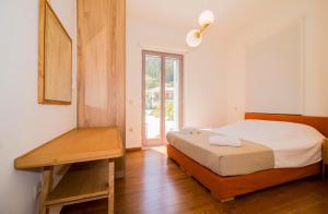 1 dormitorio con cama y mesa de madera en Laconian Collection Mystras Residence Upper Floor, en Mystras
