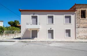 Casa blanca con balcón en una calle en Laconian Collection Mystras Residence Upper Floor, en Mystras