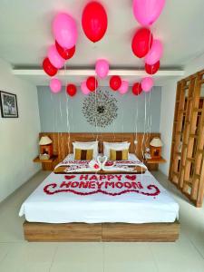 a bedroom with a bed with balloons and a happy anniversary sign at The Sakaye Villas & Spa in Legian