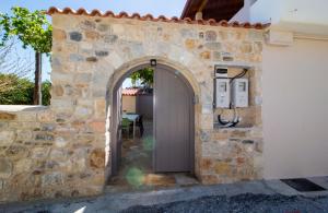 una entrada a una pared de piedra con una puerta en Laconian Collection Mystras Residence Upper Floor, en Mystras