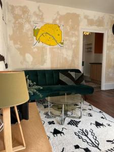 - un salon avec un canapé vert et un tapis dans l'établissement Moulins centre : Appartement N*6, à Moulins