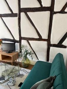 un soggiorno con divano verde e parete di Moulins centre : Appartement N*6 a Moulins
