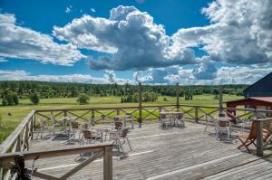 una terrazza in legno con tavoli e sedie. di Kiladalens Golf & Lodge a Nyköping