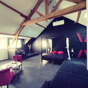 Cette chambre mansardée comprend un lit et une table. dans l'établissement Love Room à Montargis, à Montargis