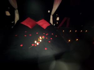 - un lit avec 2 oreillers rouges et des bougies dans l'établissement Love Room à Montargis, à Montargis