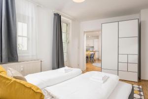 2 Betten in einem Zimmer mit Spiegel in der Unterkunft Zum Grazer Uhrturm in Graz