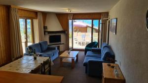 ein Wohnzimmer mit blauen Sofas und einem Tisch in der Unterkunft Greppons MOUNTAIN & RESTFUL apartments by Alpvision Résidences in Veysonnaz