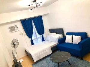 een kamer met een bed en een blauwe bank bij Avida Tower Sucat, comfortable studio type in Manilla +43 foto's