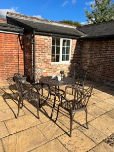 una mesa y sillas en un patio en The Old Dairy Steep,Petersfield in Collyers Estate in the South Downs National park, en Petersfield