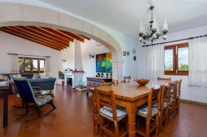 comedor y sala de estar con mesa y sillas en YourHouse Ca Na Teulera, villa with private pool, en Can Picafort