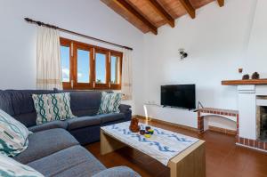 sala de estar con sofá azul y chimenea en YourHouse Ca Na Teulera, villa with private pool, en Can Picafort