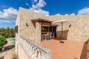 zewnętrzny widok na kamienny dom z parasolem w obiekcie YourHouse Ca Na Teulera, villa with private pool w Can Picafort