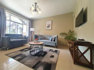 a living room with a couch and a table at Serendib Suites and Conference Center in Blantyre