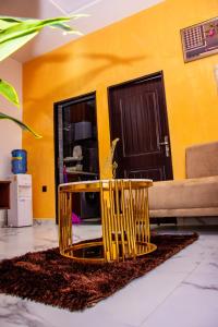 een gele kamer met een tafel en stoelen voor een deur bij NIFEWAT APARTMENT,Bris suite 1bedroom apartment gym, Netflix,WiFi in Abuja