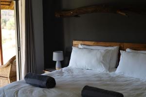 a bedroom with a white bed with a large window at Waterberg Game Lodge in Bela-Bela